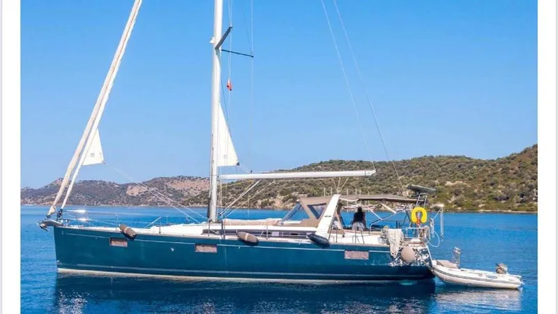  Yacht Photos Pics 2014 Beneteau Oceanis 48 sailboat on calm blue water, scenic coastal background.