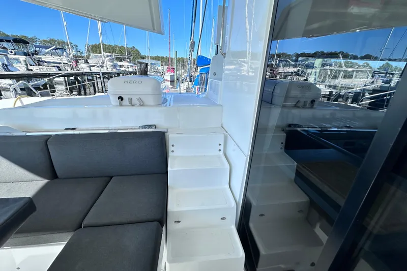 Buena Vida Yacht Photos Pics 2023 Lagoon 50 yacht interior with seating and stairs, docked at marina.