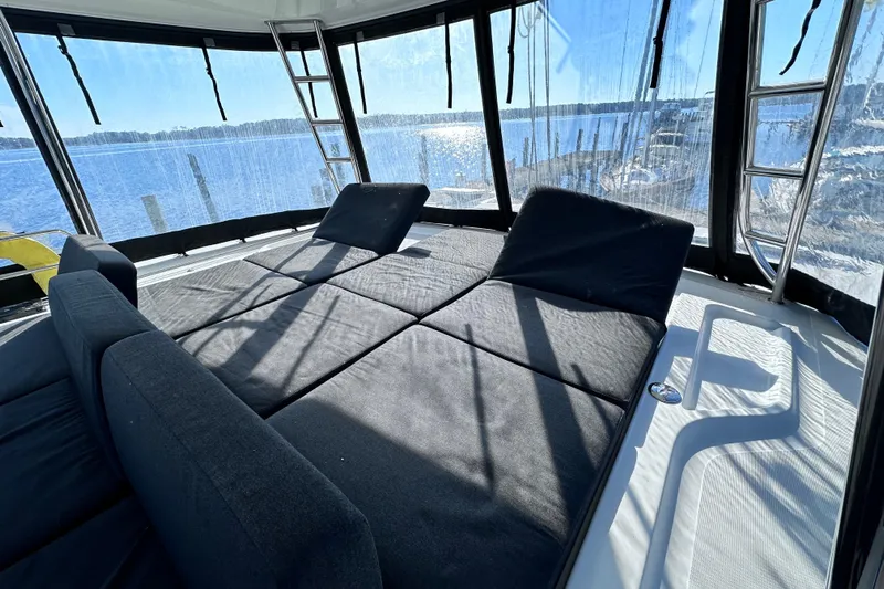 Buena Vida Yacht Photos Pics 2023 Lagoon 50 yacht interior with sunlit lounge area and panoramic windows.
