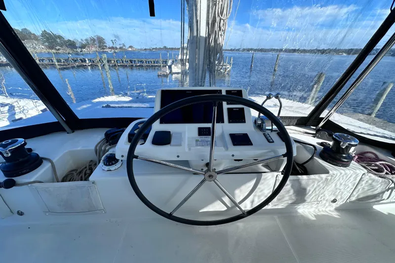 Buena Vida Yacht Photos Pics Cockpit of 2023 Lagoon 50 catamaran with steering wheel and navigation controls.
