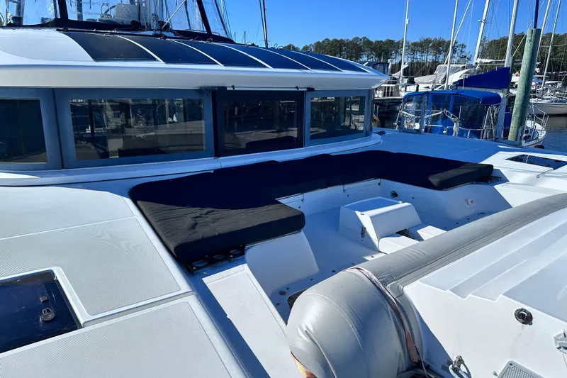 Buena Vida Yacht Photos Pics 2023 Lagoon 50 yacht deck with seating area in marina setting.