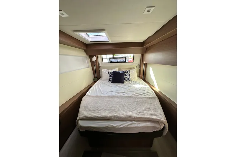 Buena Vida Yacht Photos Pics Luxurious cabin interior of 2023 Lagoon 50 yacht with cozy bed and skylight.