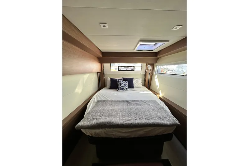 Buena Vida Yacht Photos Pics Luxurious cabin interior of 2023 Lagoon 50 yacht with cozy bedding and natural light.