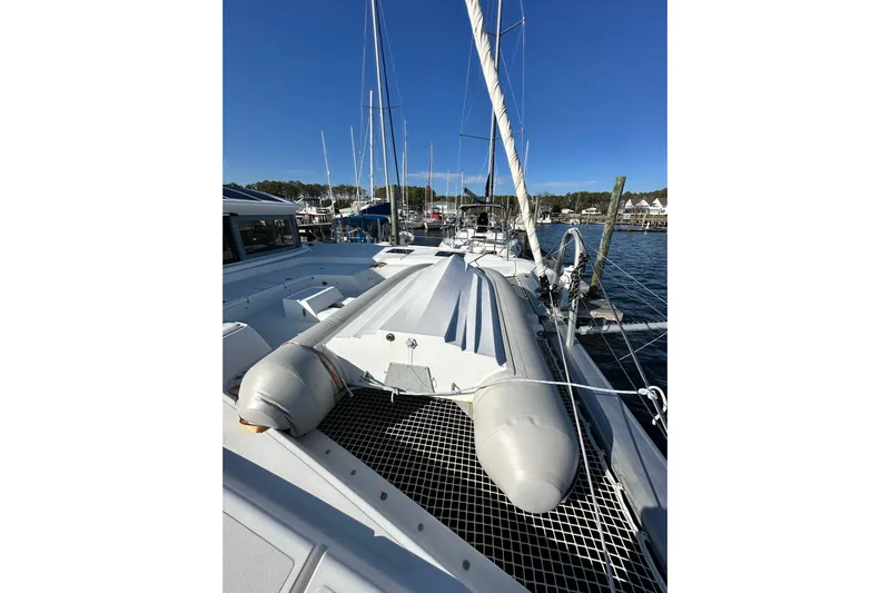 Buena Vida Yacht Photos Pics 2023 Lagoon 50 catamaran docked at marina, featuring spacious deck and inflatable dinghy.