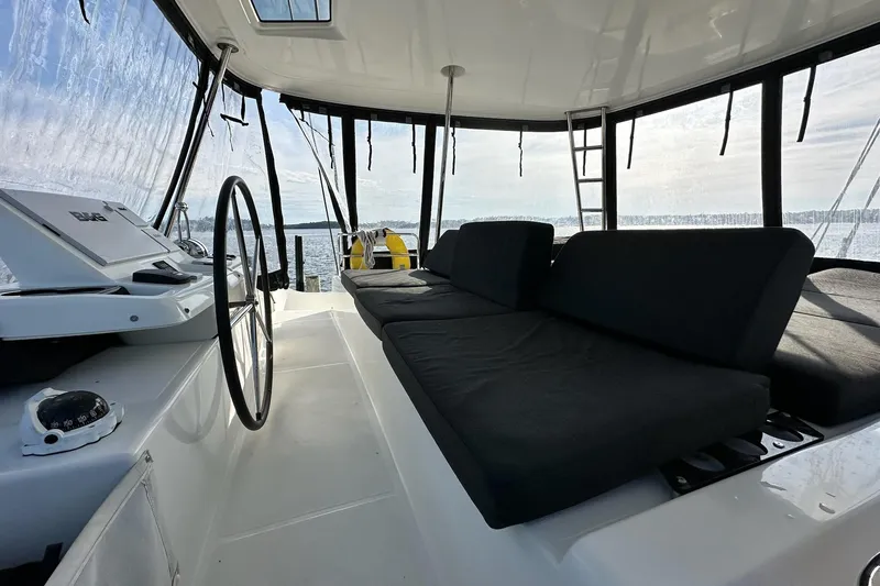 Buena Vida Yacht Photos Pics 2023 Lagoon 50 yacht interior with steering wheel and cushioned seating.
