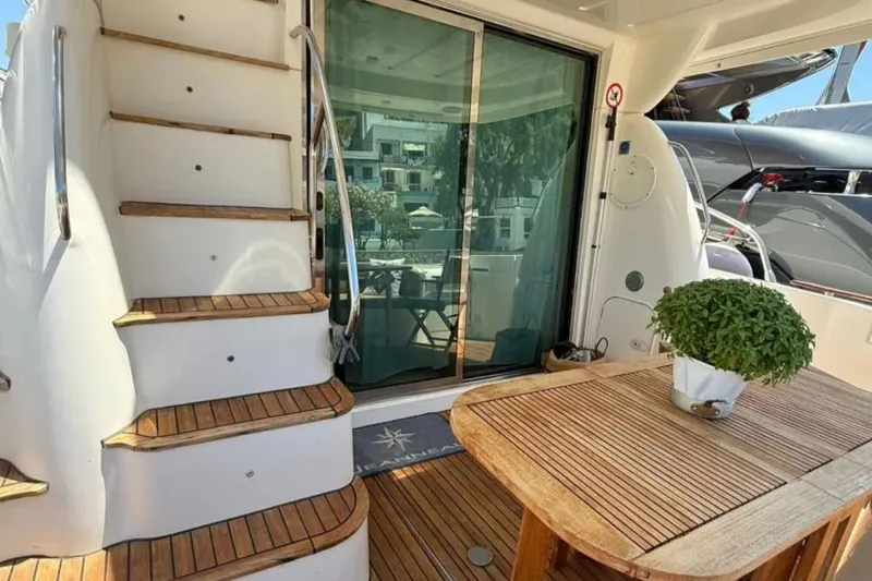  Yacht Photos Pics 2005 Jeanneau Prestige 46 yacht deck with wooden stairs and table, potted plant.