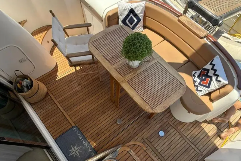  Yacht Photos Pics Luxurious Jeanneau Prestige 46 yacht deck with wooden table, seating, and decorative cushions, 2005 model.