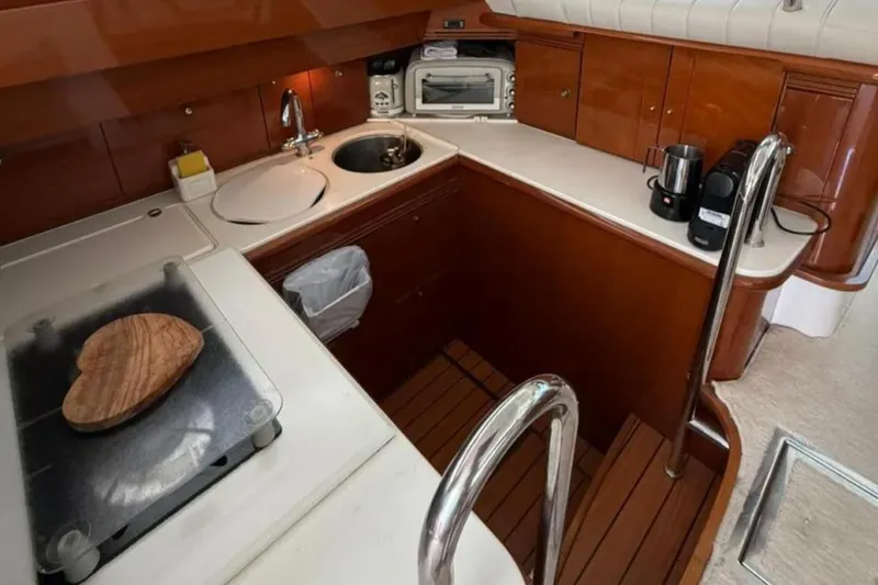  Yacht Photos Pics Luxurious 2005 Jeanneau Prestige 46 yacht kitchen with wood cabinetry and modern appliances.