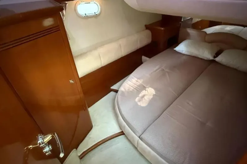  Yacht Photos Pics Luxurious cabin interior of 2005 Jeanneau Prestige 46 yacht with cozy bed and wooden furnishings.