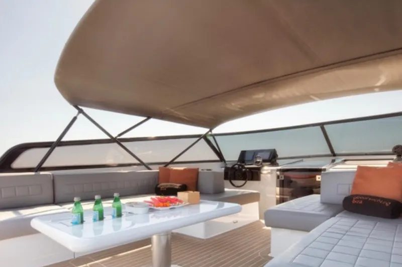 Sin Nombre Yacht Photos Pics Luxurious 2012 VanDutch 55 yacht interior with seating, table, and refreshments under a canopy.