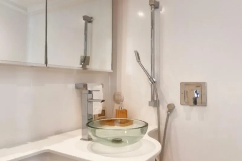 Sin Nombre Yacht Photos Pics Modern bathroom interior on 2012 VanDutch 55 yacht, featuring glass sink and sleek fixtures.