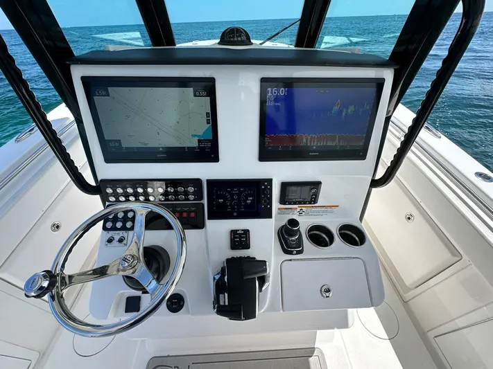 Yacht Photos Pics 2025 Caymas 341 CC boat dashboard with dual screens and steering wheel on open sea.