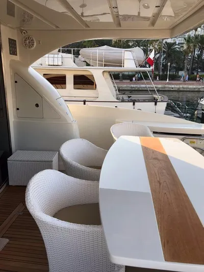  Yacht Photos Pics Luxury yacht deck with white wicker chairs and wooden table, Dominator 640 S, 2014 model.