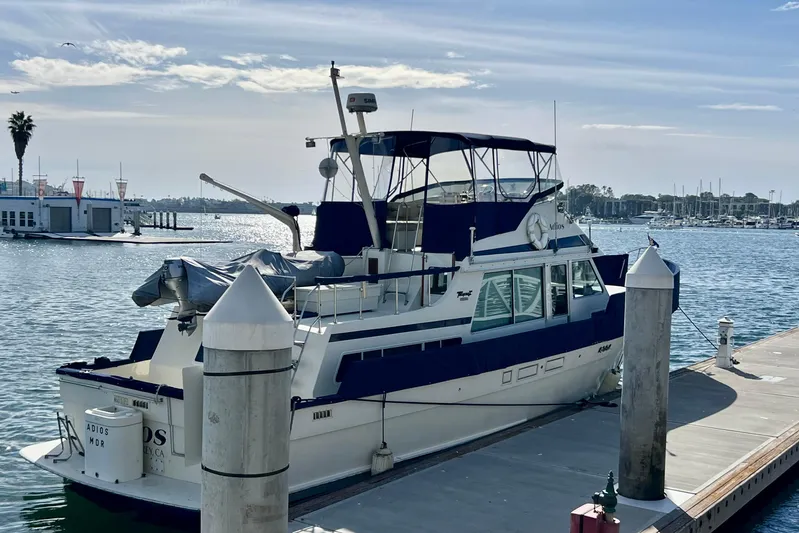 Adios Yacht Photos Pics 1985 Tollycraft 48 Cockpit Motor Yacht docked at marina under clear sky.