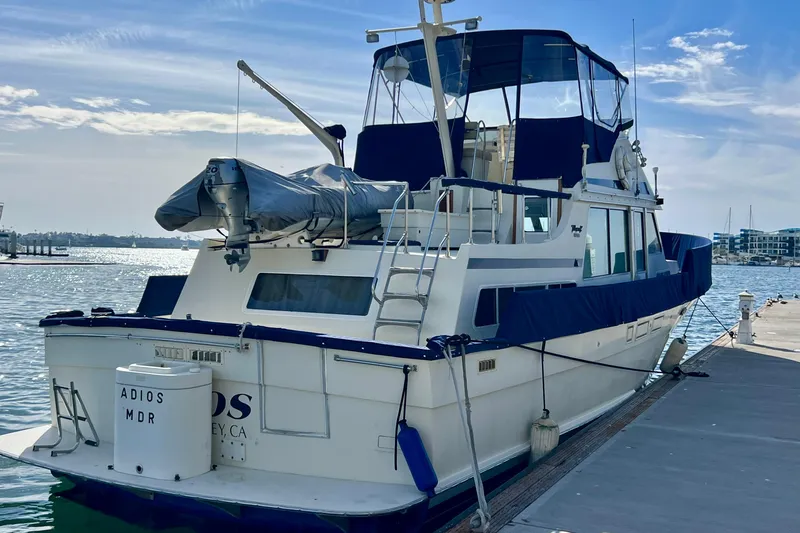 Adios Yacht Photos Pics 1985 Tollycraft 48 Cockpit Motor Yacht docked at marina under clear sky.