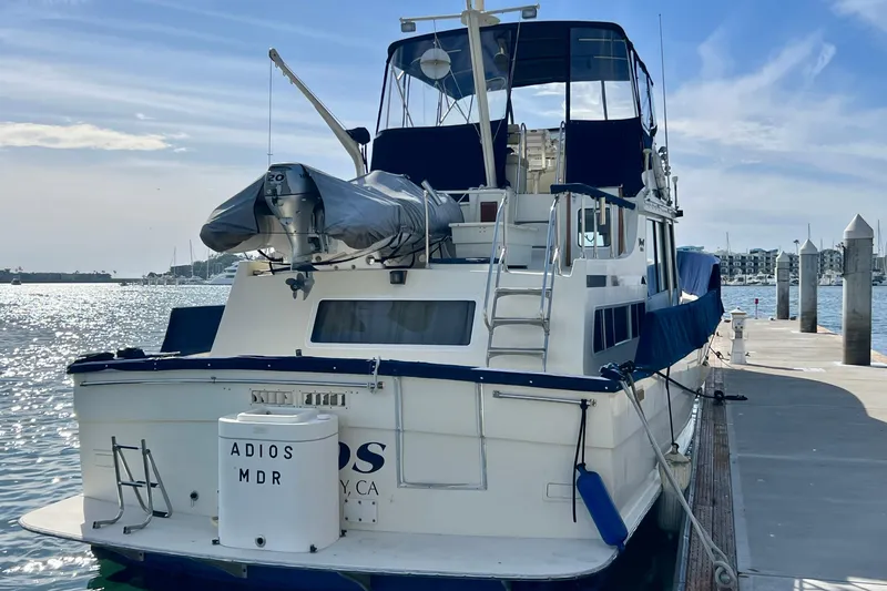 Adios Yacht Photos Pics 1985 Tollycraft 48 Cockpit Motor Yacht docked at marina under clear sky.