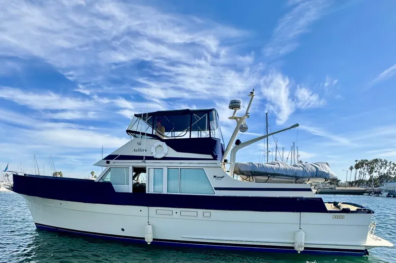 Adios Yacht Photos Pics 1985 Tollycraft 48 Cockpit Motor Yacht on calm water under blue sky.