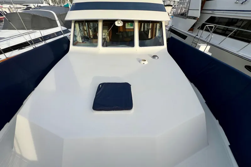 Adios Yacht Photos Pics 1985 Tollycraft 48 Cockpit Motor Yacht deck with blue accents and windows.