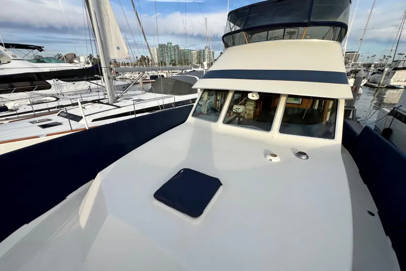 Adios Yacht Photos Pics 1985 Tollycraft 48 Cockpit Motor Yacht docked in marina, showcasing sleek design and spacious deck.