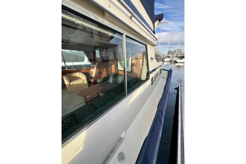 Adios Yacht Photos Pics 1985 Tollycraft 48 Cockpit Motor Yacht docked, showcasing interior seating and exterior design.