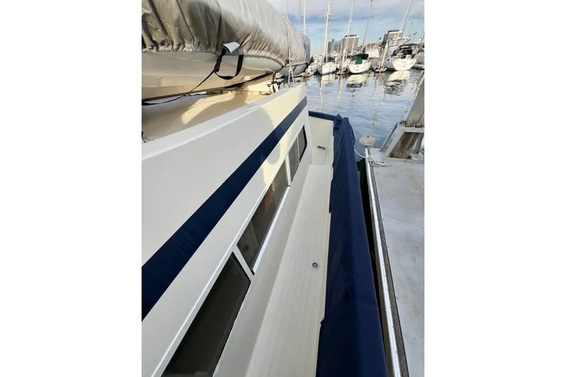 Adios Yacht Photos Pics 1985 Tollycraft 48 Cockpit Motor Yacht docked, showcasing sleek design and spacious deck.