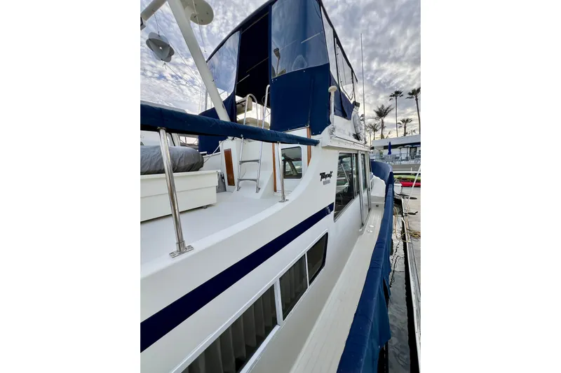 Adios Yacht Photos Pics 1985 Tollycraft 48 Cockpit Motor Yacht docked, featuring sleek design and blue accents.