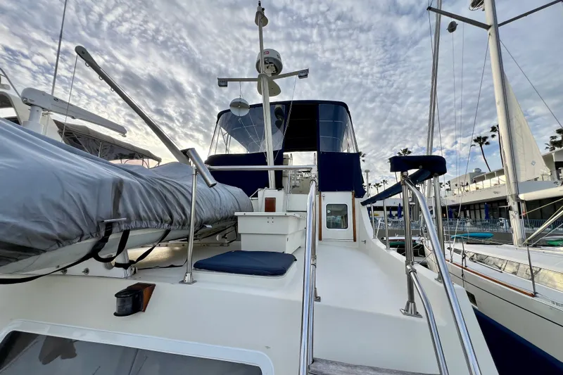 Adios Yacht Photos Pics 1985 Tollycraft 48 Cockpit Motor Yacht docked under a cloudy sky.