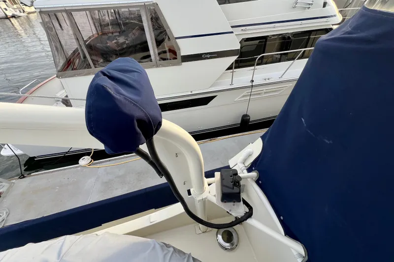 Adios Yacht Photos Pics 1985 Tollycraft 48 Cockpit Motor Yacht docked, featuring covered equipment and adjacent vessel.