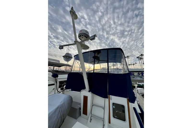 Adios Yacht Photos Pics 1985 Tollycraft 48 Cockpit Motor Yacht under a dramatic cloudy sky.