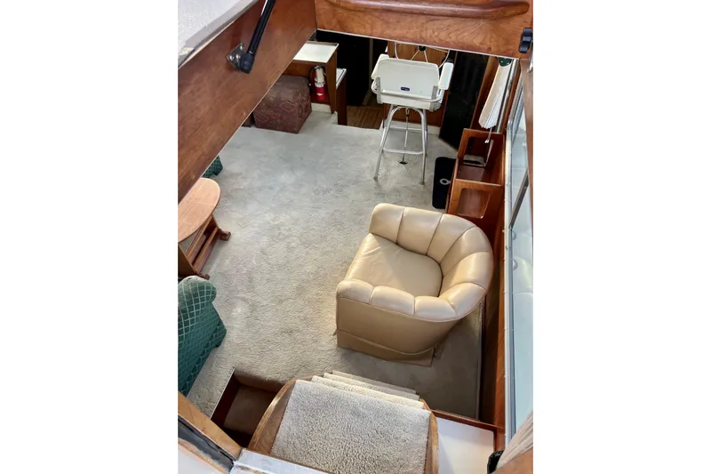 Adios Yacht Photos Pics Interior of 1985 Tollycraft 48 Cockpit Motor Yacht with beige armchair and carpet.