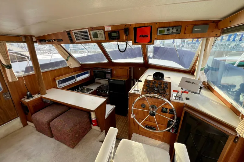 Adios Yacht Photos Pics 1985 Tollycraft 48 Cockpit Motor Yacht interior with helm, navigation equipment, and seating area.