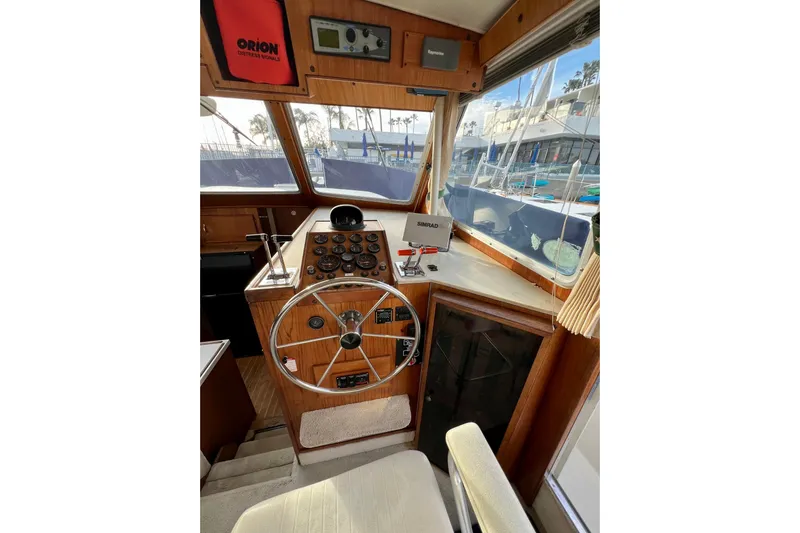 Adios Yacht Photos Pics 1985 Tollycraft 48 Cockpit Motor Yacht helm with steering wheel and navigation equipment.