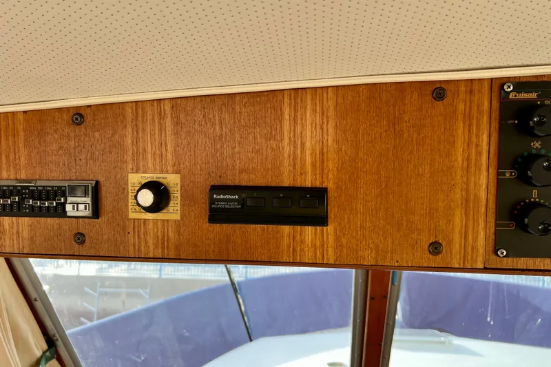 Adios Yacht Photos Pics Control panel of 1985 Tollycraft 48 Cockpit Motor Yacht with wood finish and audio controls.