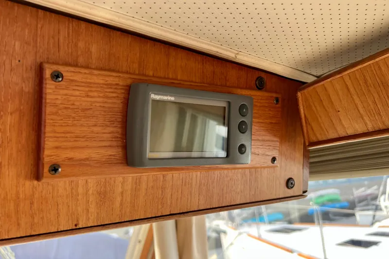 Adios Yacht Photos Pics Raymarine display on 1985 Tollycraft 48 Cockpit Motor Yacht's wooden interior panel.
