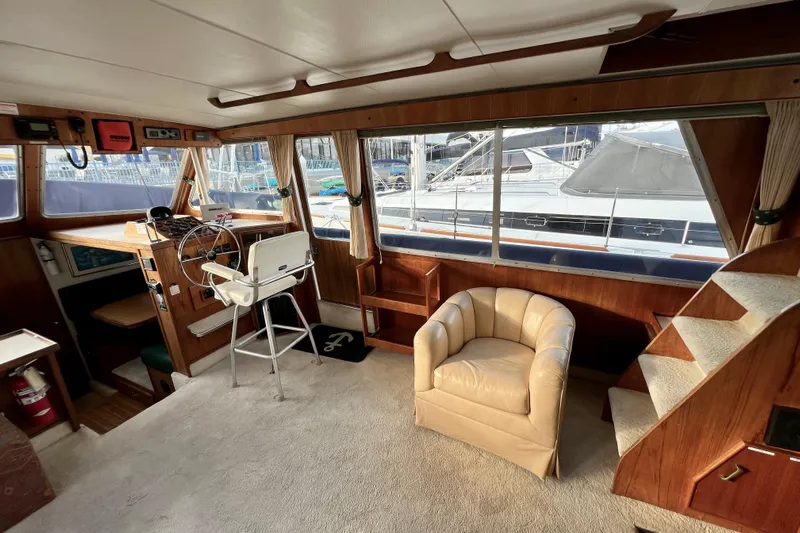 Adios Yacht Photos Pics 1985 Tollycraft 48 Cockpit Motor Yacht interior with helm, chair, and stairs.