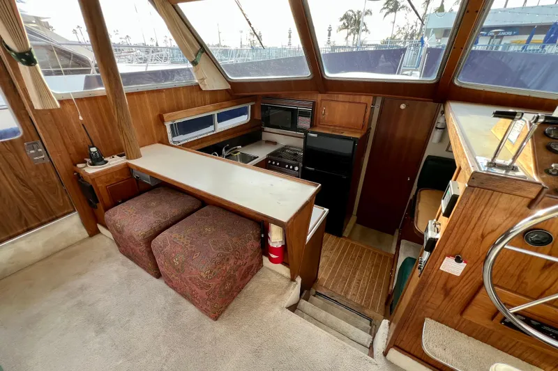 Adios Yacht Photos Pics Interior of 1985 Tollycraft 48 Cockpit Motor Yacht with kitchen and seating area.
