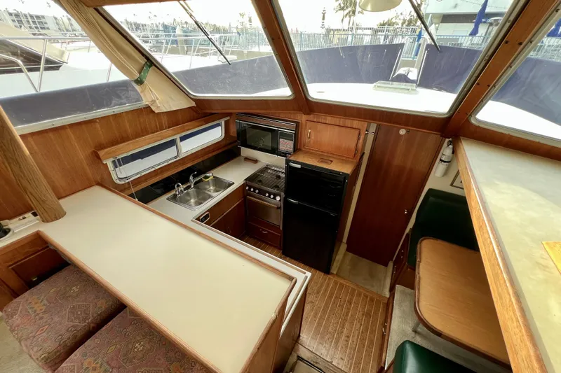 Adios Yacht Photos Pics 1985 Tollycraft 48 Cockpit Motor Yacht interior with kitchen and dining area.