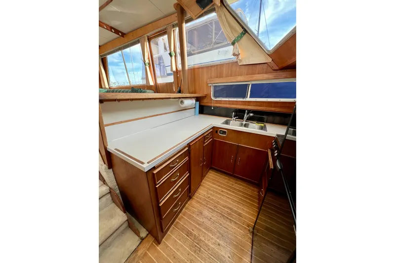Adios Yacht Photos Pics 1985 Tollycraft 48 Cockpit Motor Yacht kitchen with wood cabinetry and countertops.