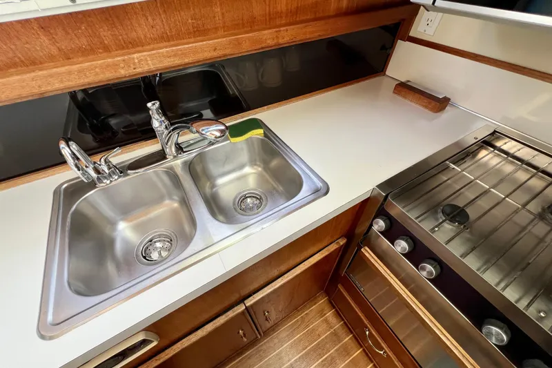 Adios Yacht Photos Pics 1985 Tollycraft 48 Cockpit Motor Yacht kitchen with stainless steel sink and stove.