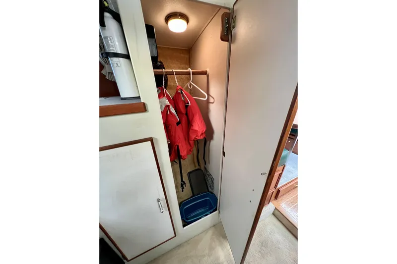 Adios Yacht Photos Pics Closet interior of 1985 Tollycraft 48 Cockpit Motor Yacht with red jackets and storage.