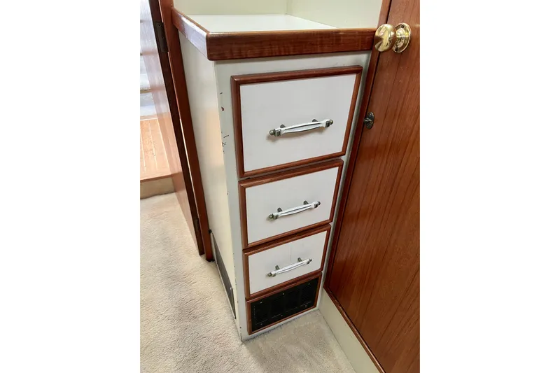 Adios Yacht Photos Pics 1985 Tollycraft 48 Cockpit Motor Yacht interior with wooden drawers and carpeted floor.