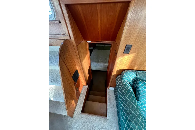 Adios Yacht Photos Pics Interior view of 1985 Tollycraft 48 Cockpit Motor Yacht, featuring wooden stairs and cozy seating.