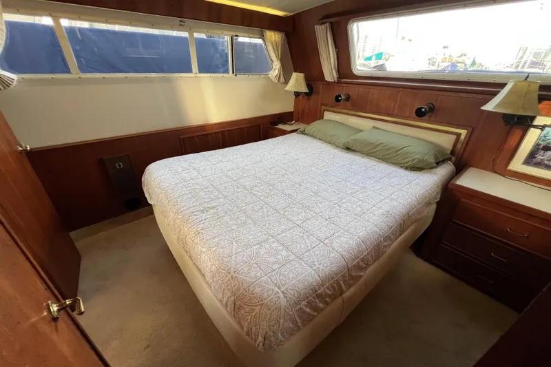 Adios Yacht Photos Pics 1985 Tollycraft 48 Cockpit Motor Yacht bedroom with cozy bed and wooden interior.