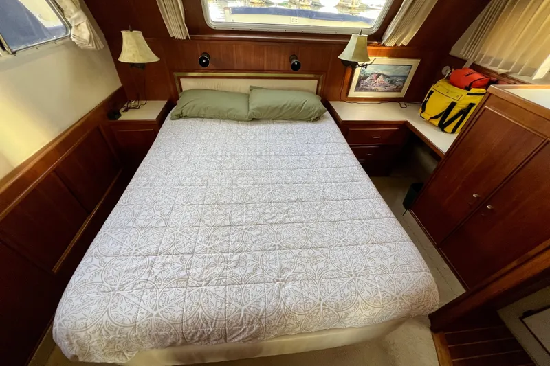 Adios Yacht Photos Pics Cozy bedroom in 1985 Tollycraft 48 Cockpit Motor Yacht with elegant wood paneling.