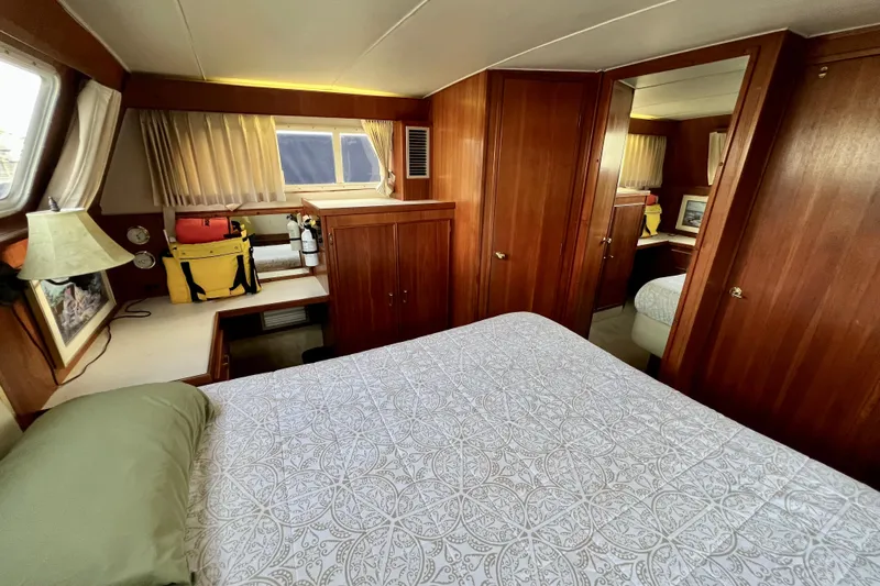 Adios Yacht Photos Pics 1985 Tollycraft 48 Cockpit Motor Yacht bedroom with wood paneling and cozy decor.