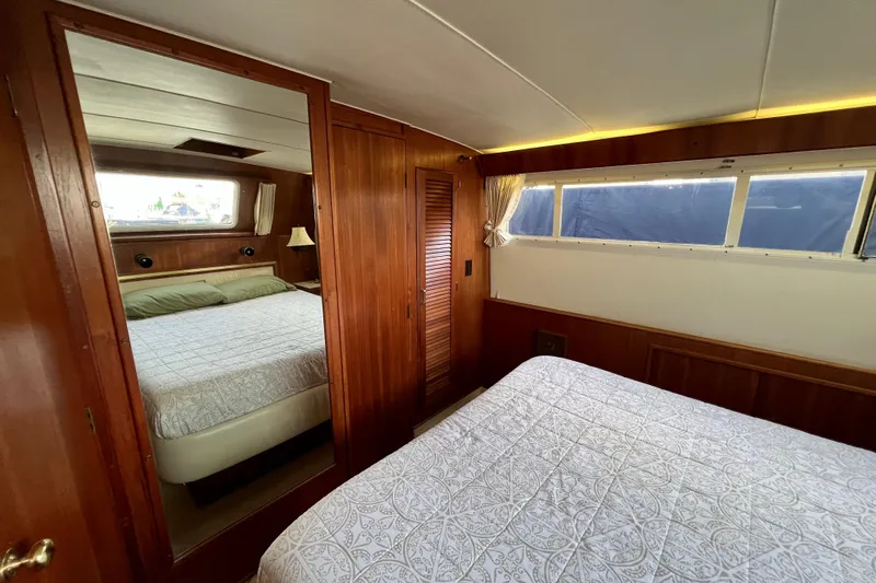 Adios Yacht Photos Pics Interior of 1985 Tollycraft 48 Cockpit Motor Yacht with wood paneling and cozy bedding.