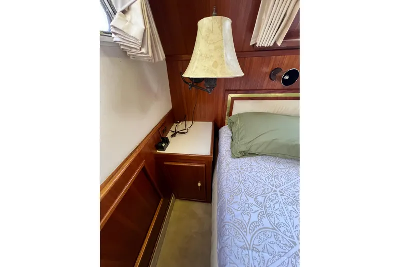 Adios Yacht Photos Pics Cozy bedroom interior of 1985 Tollycraft 48 Cockpit Motor Yacht with elegant wood paneling.
