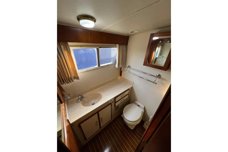 Adios Yacht Photos Pics 1985 Tollycraft 48 Cockpit Motor Yacht bathroom with sink, toilet, and window.