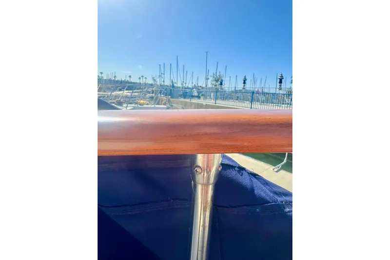 Adios Yacht Photos Pics 1985 Tollycraft 48 Cockpit Motor Yacht railing with marina background under clear blue sky.