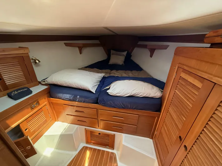 Chance Yacht Photos Pics Cozy cabin interior of 1999 Tartan 4100 sailboat with wooden furnishings and comfortable bedding.